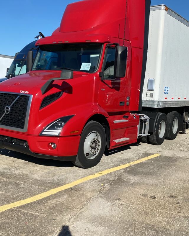 Red Volvo day cab, one of a matched pair, hooked to a 53-foot trailer