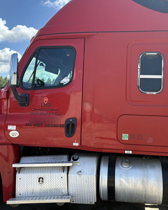 Red LMB Distributors Freightliner Cascadia sleeper with company logo