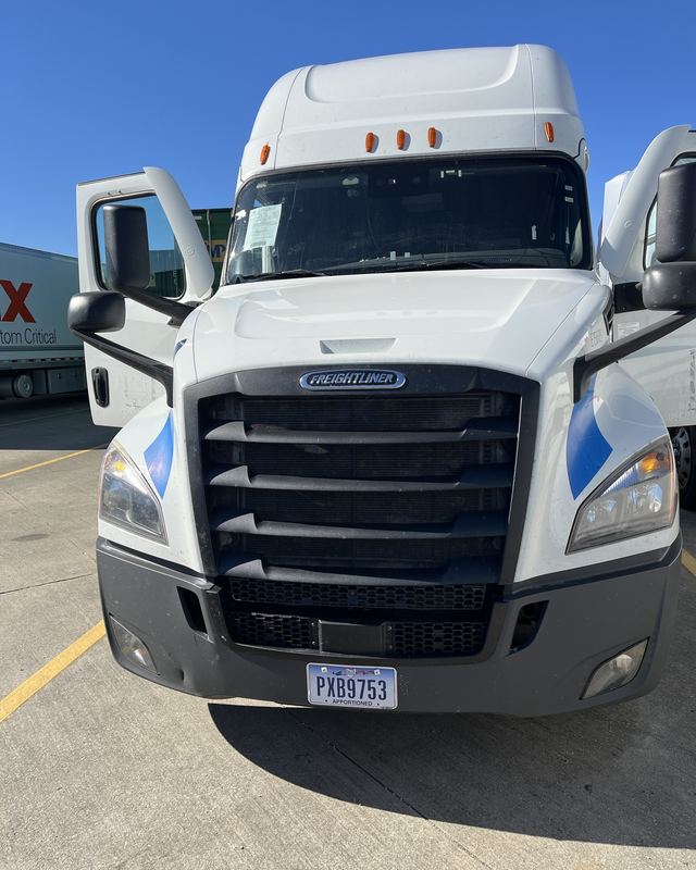 White Freightliner Cascadia sleeper at a FedEx Custom Critical yard